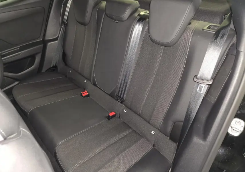 Vue intérieure de la banquette arrière noire de l'Opel Mokka-e 2025 avec ceintures et appuie-têtes visibles.