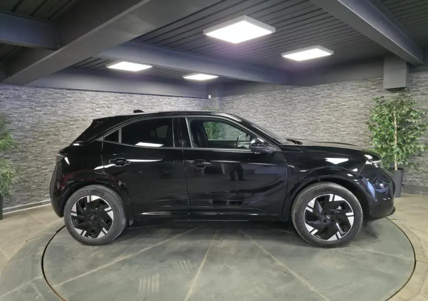 Opel Mokka-e noir vue de profil côté gauche, jantes alliage 18'' diamantées, intérieur visible à travers les vitres.