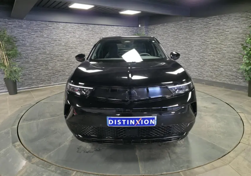 Vue avant d'un Opel Mokka-e noir 2025 avec calandre noire et phares Matrix LED dans un showroom.