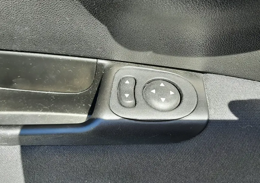 Gros plan sur les commandes électriques des rétroviseurs côté conducteur de la FIAT 500 bleue de 2018.