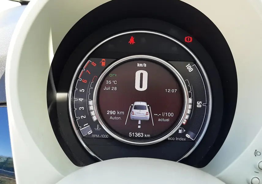 Vue rapprochée du tableau de bord numérique de la Fiat 500 bleu, affichant vitesse zéro et compteur kilométrique.
