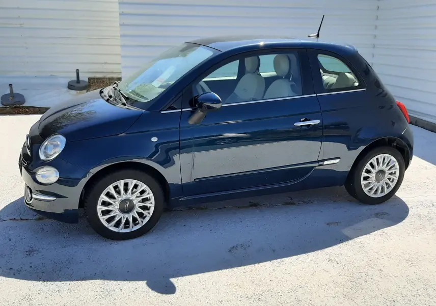 Profil droit d'une FIAT 500 bleu 2018, finition Lounge, avec jantes alliage et intérieur clair visible.
