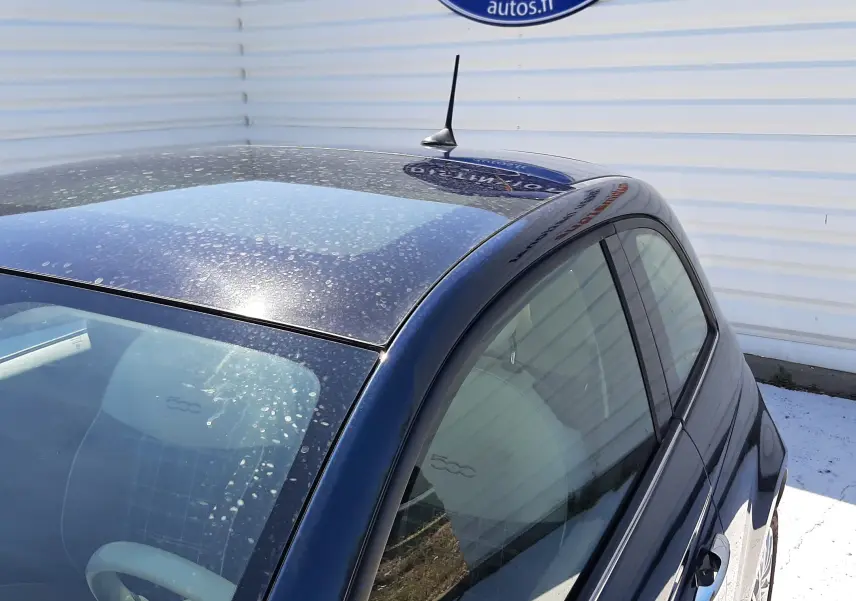 Vue plongeante sur l'arrière droit d'une FIAT 500 bleu, mettant en valeur la silhouette compacte et le toit arrondi.