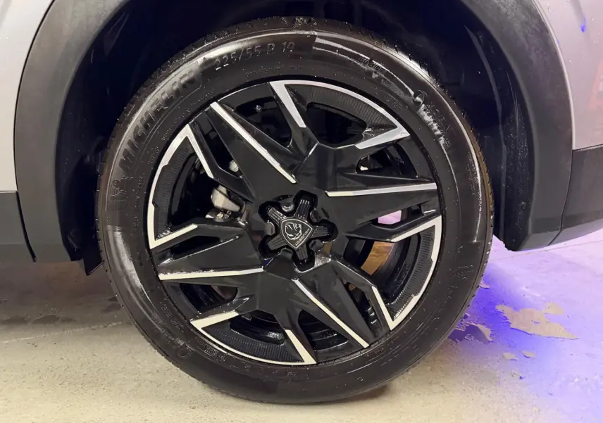 Gros plan sur la roue avant droite du Peugeot 3008 gris 2025, avec jante alliage noire et détails argentés.