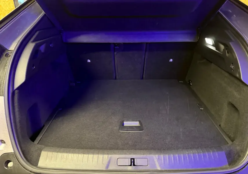 Coffre ouvert du Peugeot 3008 gris 2025, vue arrière montrant un espace de chargement propre et éclairé.