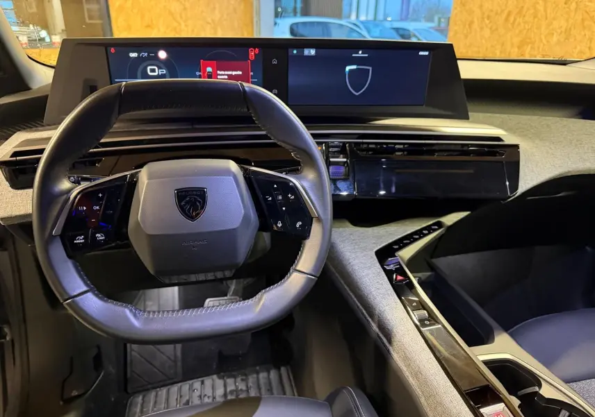 Vue intérieure du tableau de bord du Peugeot 3008 1.2 Hybrid 136 Allure 2025, volant compact et écran numérique large.