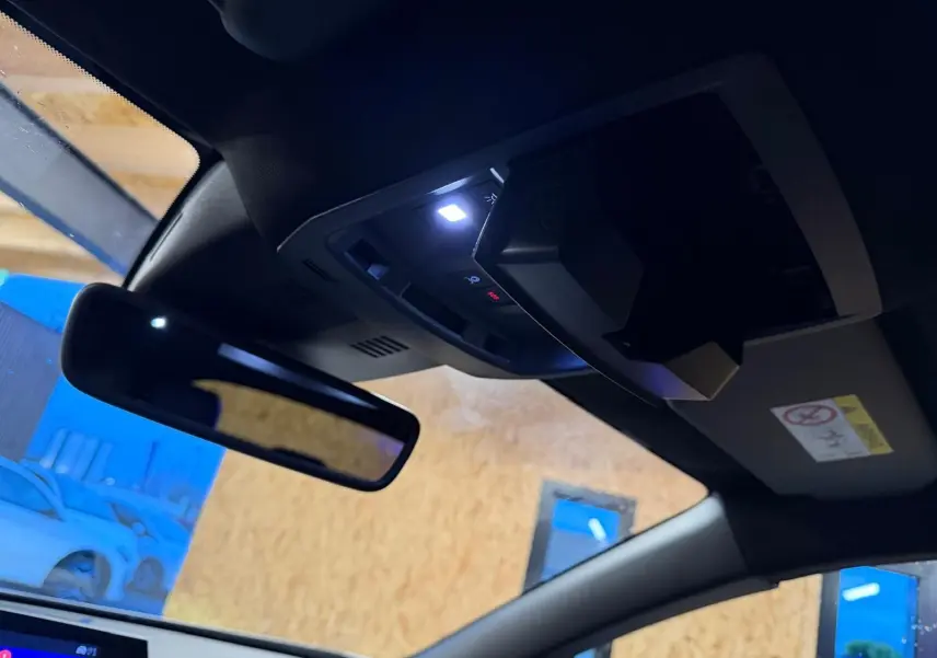 Vue intérieure du toit d’un Peugeot 3008 gris 2025, avec miroir de courtoisie et éclairage LED activé.