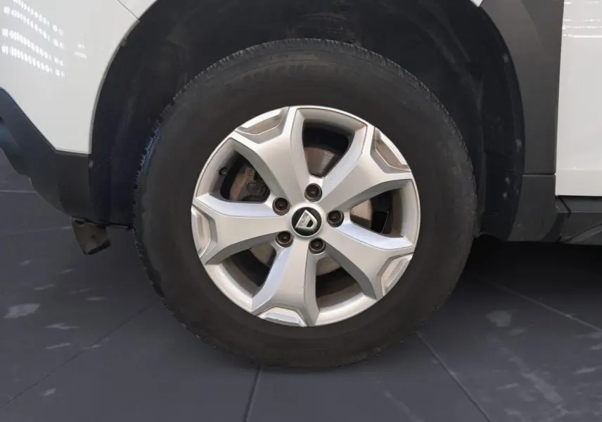 Vue intérieure côté conducteur du tableau de bord noir et volant du Dacia Duster blanc 2021, version diesel 4x2.