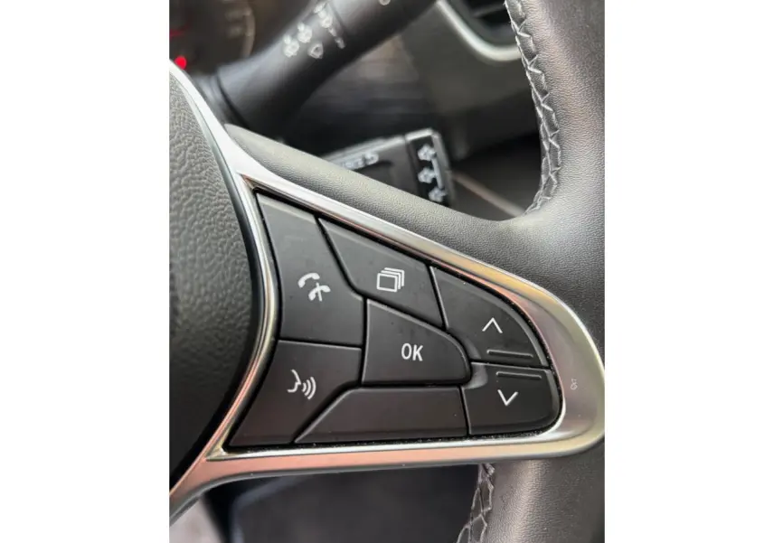 Gros plan sur les commandes multifonctions noires du volant du Renault Trafic Fourgon gris clair, finition 2022.