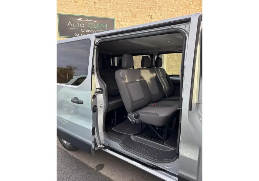 Vue côté droit du Renault Trafic Fourgon gris clair 2022 avec porte latérale ouverte et sièges passagers visibles.