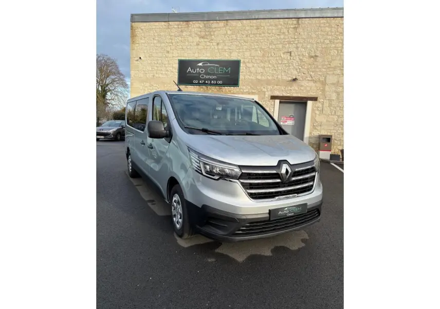 Renault Trafic Fourgon gris clair vu en 3/4 avant droit, avec calandre noire et phares LED distinctifs.