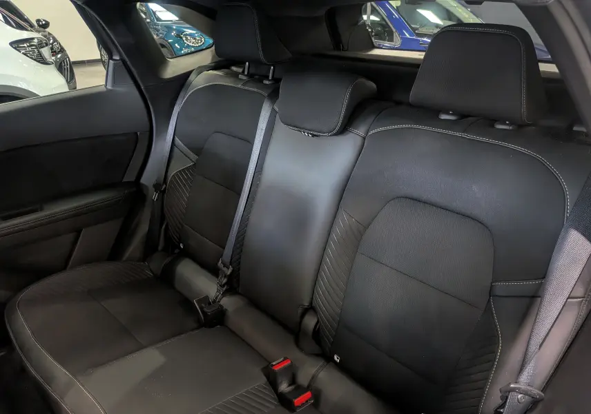 Vue intérieure sur les sièges arrière en cuir noir avec surpiqûres contrastantes de la Renault Symbioz E-TECH 2025.