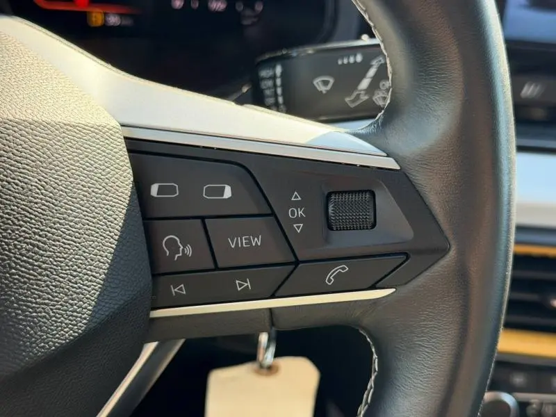 Gros plan sur les commandes multifonctions à droite du volant cuir du SEAT Arona gris Magnétique Métal 2025.