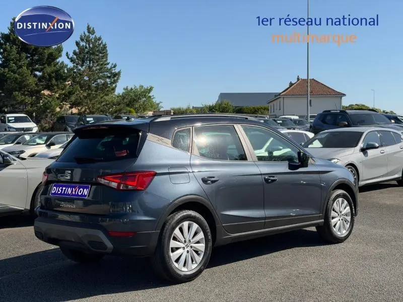 SEAT Arona 2025 gris Magnétique Métal avec toit noir, vue 3/4 arrière côté gauche sur parking extérieur.