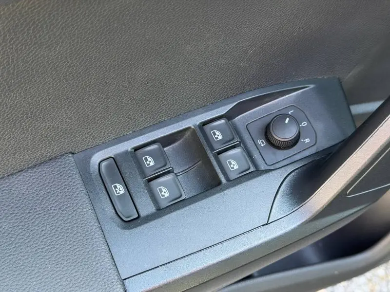 Gros plan sur les commandes de lève-vitres et réglage des rétroviseurs côté conducteur du SEAT Arona gris Magnétique Métal.