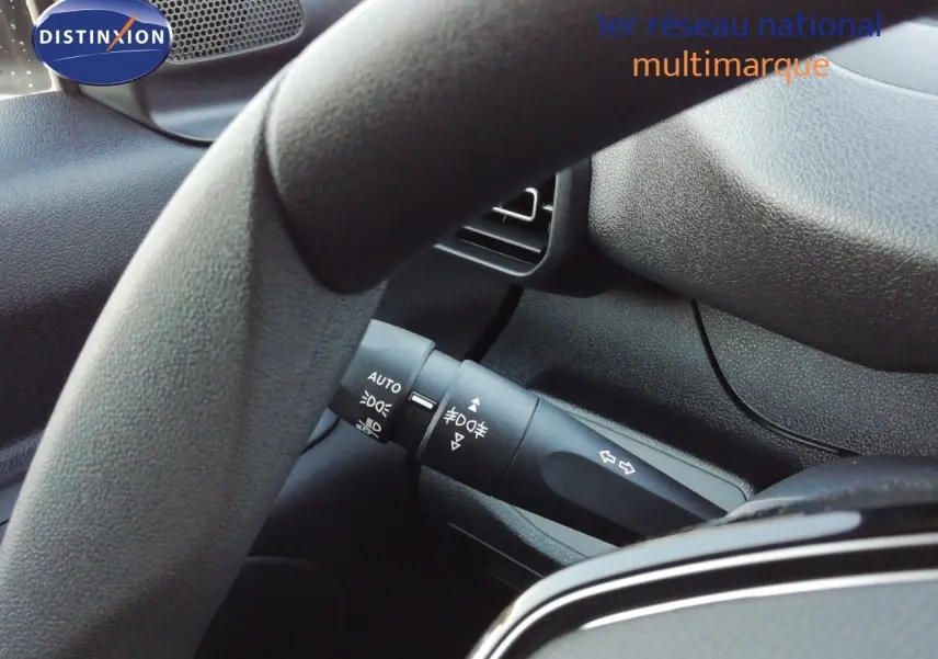 Gros plan sur la manette de clignotants et commandes d’éclairage du Peugeot Partner blanc Kaolin, intérieur gris.