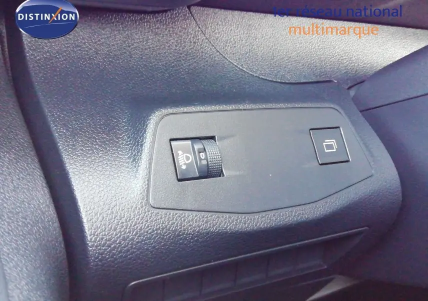 Détail intérieur montrant les commandes de réglage des phares et du tableau de bord du Peugeot Partner blanc Kaolin 2026.