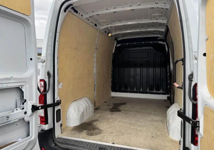 Vue arrière du Renault Master blanc 2022, montrant l'espace de chargement avec habillage bois et portes arrière ouvertes.