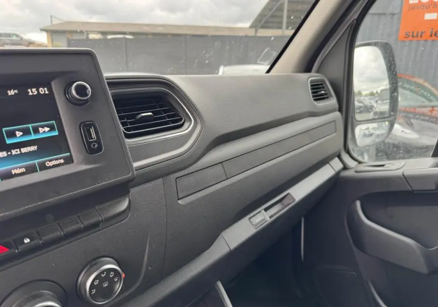 Tableau de bord côté passager du Renault Master blanc 2022 avec écran tactile et commandes climatisation visibles.