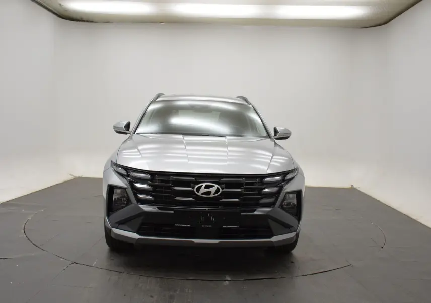 Hyundai Tucson 2025 Shimmering Silver en 3/4 avant droit, avec jantes 18 pouces et calandre noire distinctive.