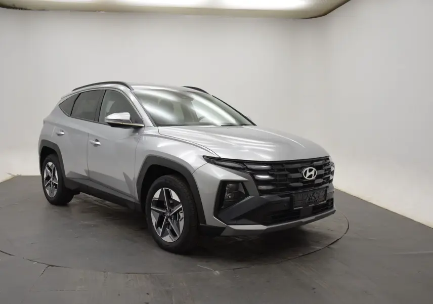 Vue frontale d'un Hyundai Tucson 2025 gris argenté avec calandre noire et feux LED intégrés.