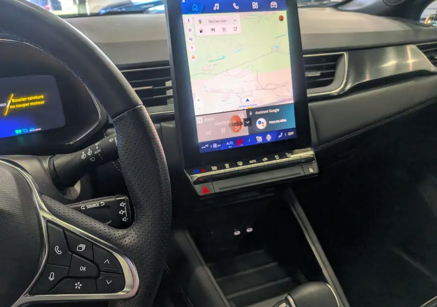 Intérieur du Renault Symbioz E-TECH 2025, vue du tableau de bord côté gauche avec écran tactile vertical et volant cuir noir.