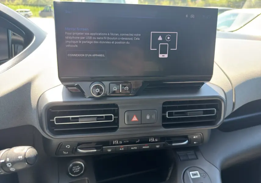 Vue rapprochée de la console centrale du Peugeot Rifter 2026 avec écran tactile, commandes climatisation et bouton start/stop.
