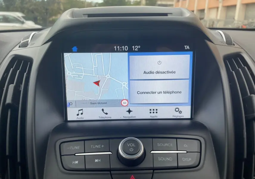 Vue rapprochée de l'écran tactile et des commandes centrales du Ford Kuga gris 2017 avec navigation affichée.