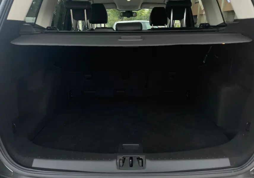 Coffre ouvert en vue arrière d'un Ford Kuga gris 2017, montrant l'espace de chargement et la plage arrière.