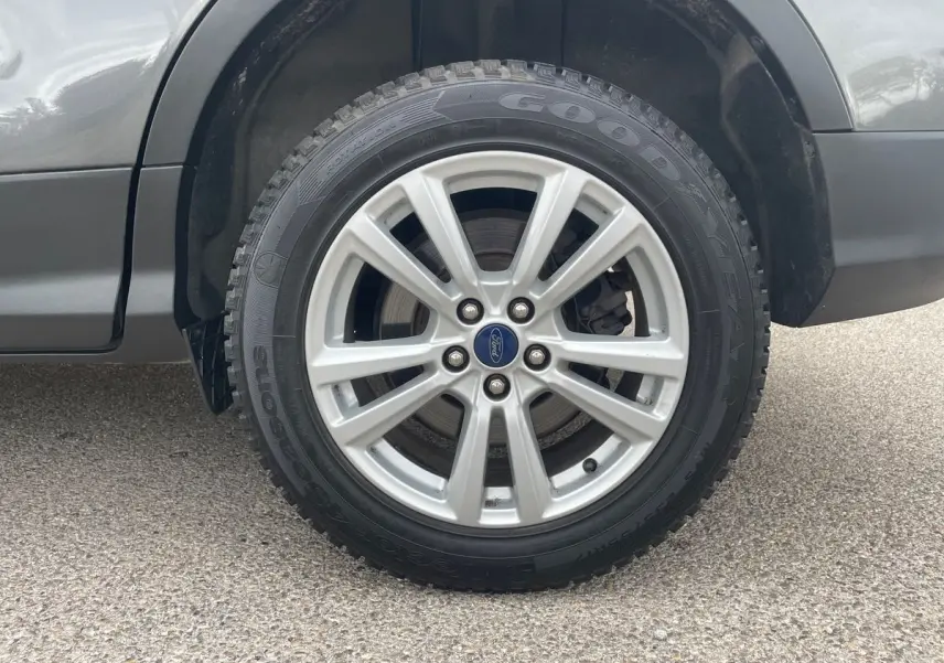 Gros plan sur la roue avant droite du Ford Kuga gris 2017, avec jante alliage et pneu Goodyear.