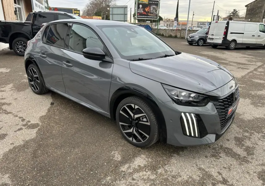 Peugeot 208 Hybrid 110 gris vue 3/4 avant droit, avec jantes alliage 17 pouces et feux LED verticaux distinctifs.