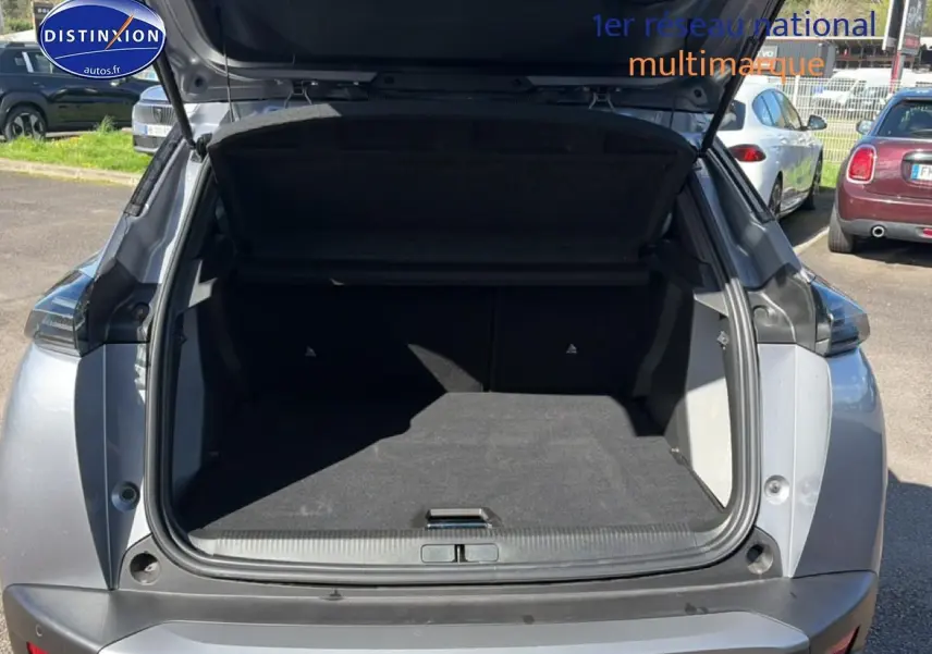Coffre ouvert d'un Peugeot 2008 gris artense vu de l'arrière, montrant l'espace de chargement vide.