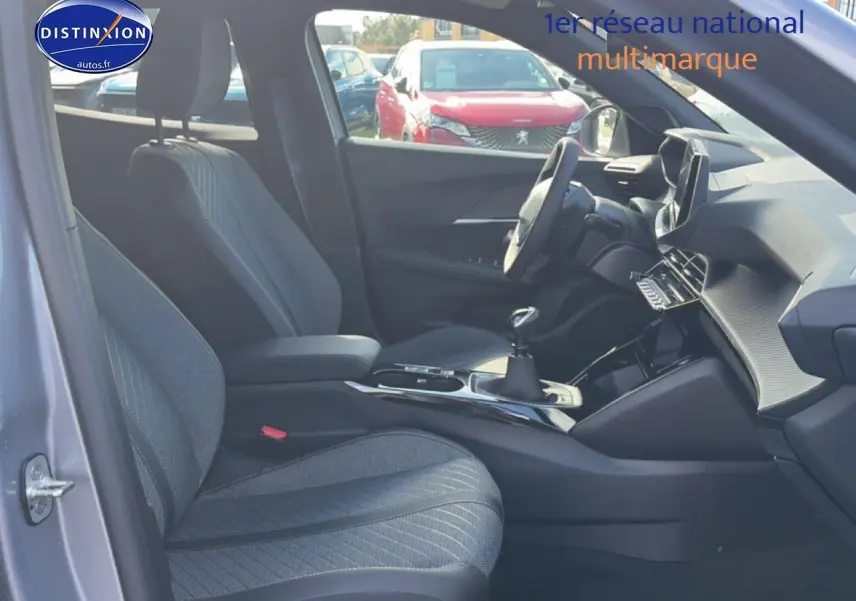 Vue intérieure côté conducteur du Peugeot 2008 2025 gris Artense, montrant sièges et tableau de bord moderne.