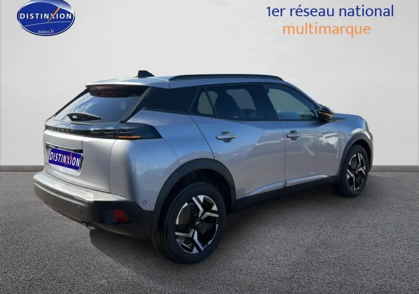 Peugeot 2008 gris artense en 3/4 arrière droit, avec jantes alu et becquet arrière visible.