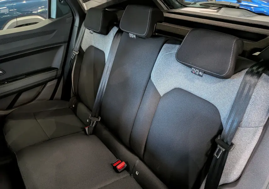 Vue intérieure des sièges arrière en tissu noir et gris du Dacia Duster Hybrid-G 150 CH 4x4, côté gauche visible.