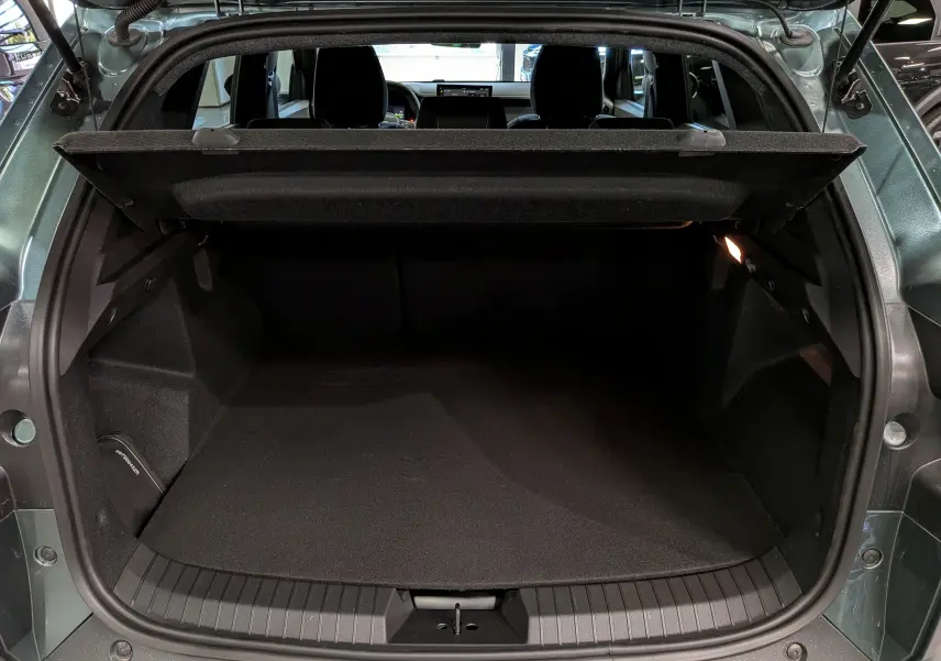 Coffre ouvert vu de l'arrière du Dacia Duster Vert Cèdre 2026, montrant l'espace de chargement vide et la tablette cache-bagages.