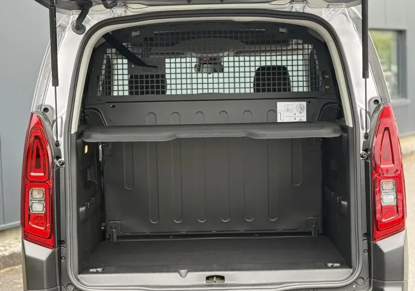 Coffre ouvert arrière d'un Citroën Berlingo Multispace gris acier, avec lunette arrière ouvrante et grille de séparation.
