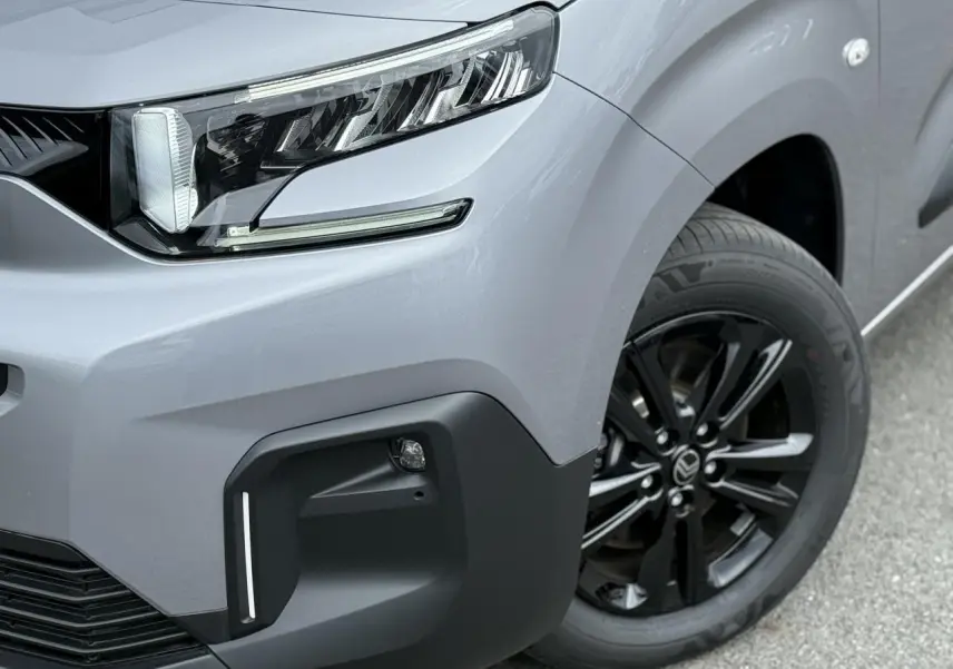 Gros plan sur l’avant droit du Citroën Berlingo gris acier 2026, avec phare LED et jante alliage noire.