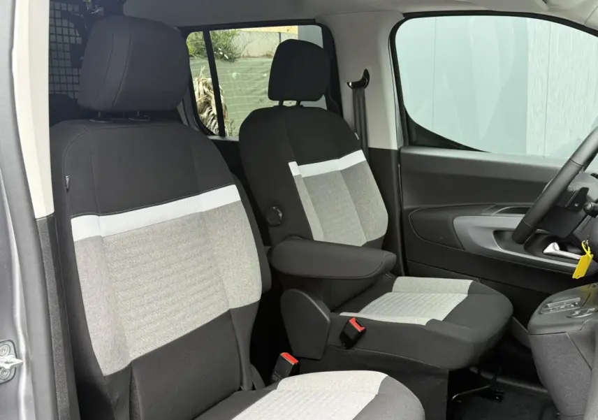 Vue intérieure côté conducteur du Citroën Berlingo Multispace gris acier, sièges bi-ton avec accoudoirs et volant multifonctions.