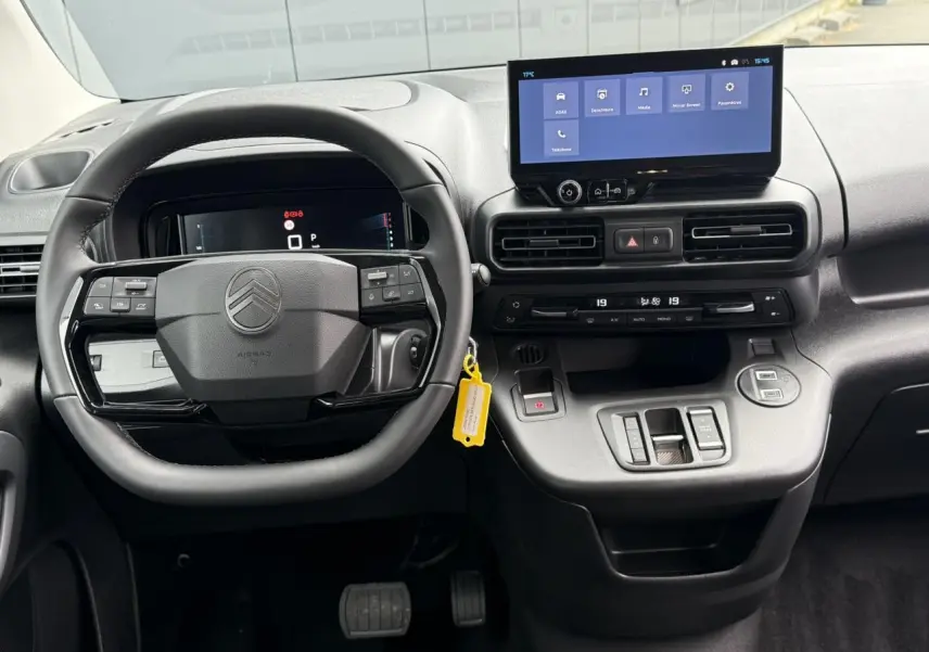 Vue frontale de l'intérieur du Citroën Berlingo Multispace 2026, tableau de bord avec écran tactile et volant multifonctions cuir.