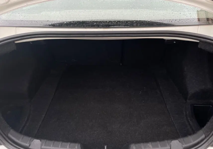 Coffre ouvert d'une BMW Série 2 Coupé F22 blanc de 2014, vue intérieure montrant un espace de rangement vide et propre.