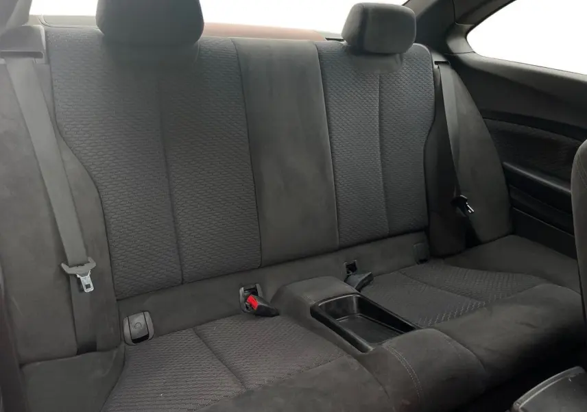 Banquette arrière en tissu noir de la BMW Série 2 Coupé F22 220d M Sport, avec accoudoir central et ceintures visibles.