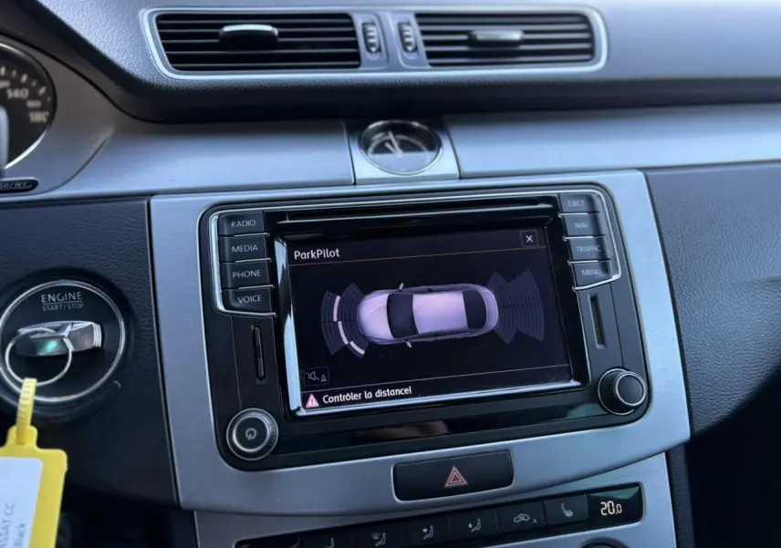 Vue rapprochée du tableau de bord de la Volkswagen Passat CC 2015, avec écran tactile affichant l'aide au stationnement.