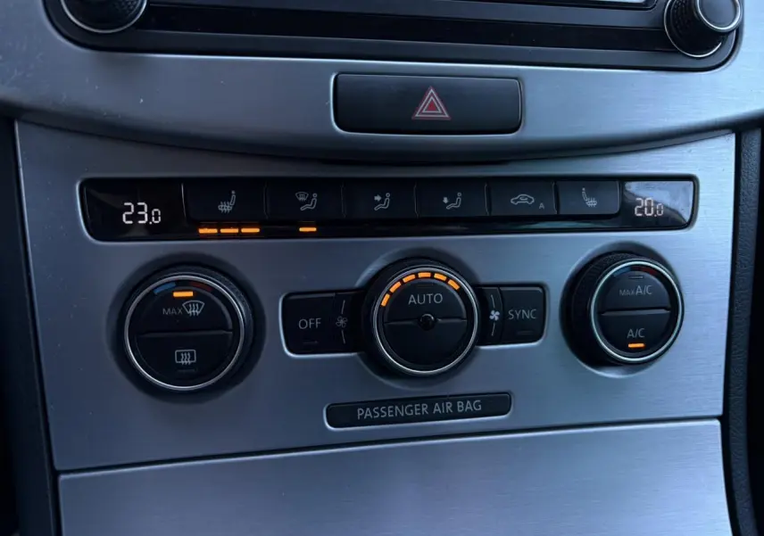 Gros plan sur la console centrale en finition aluminium brossé avec commandes de climatisation bi-zone de la Volkswagen Passat CC Deep Black.