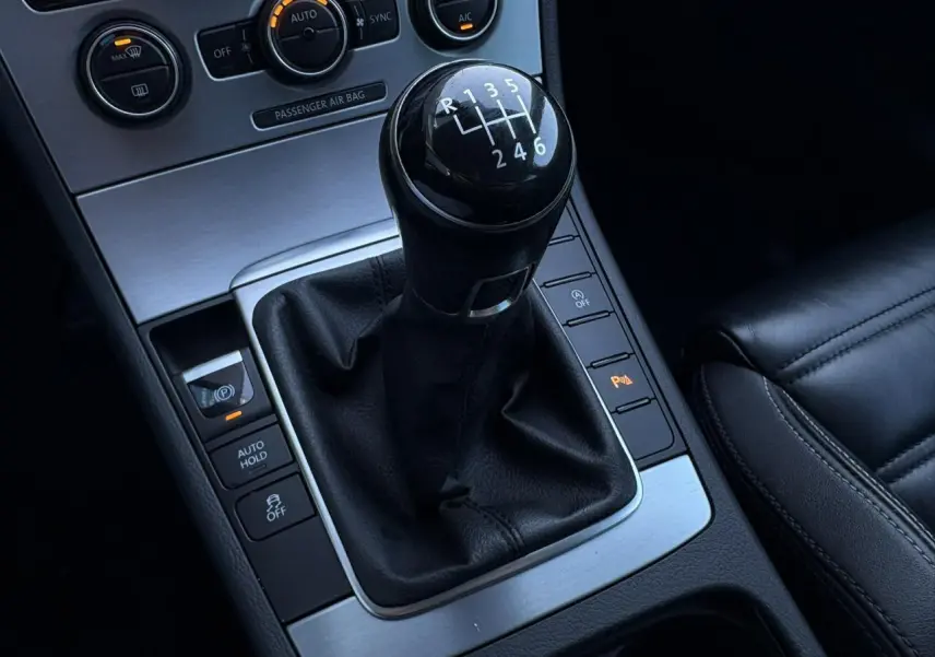 Gros plan sur le levier de vitesses manuel noir et la console centrale en aluminium brossé de la Volkswagen Passat CC Deep Black.