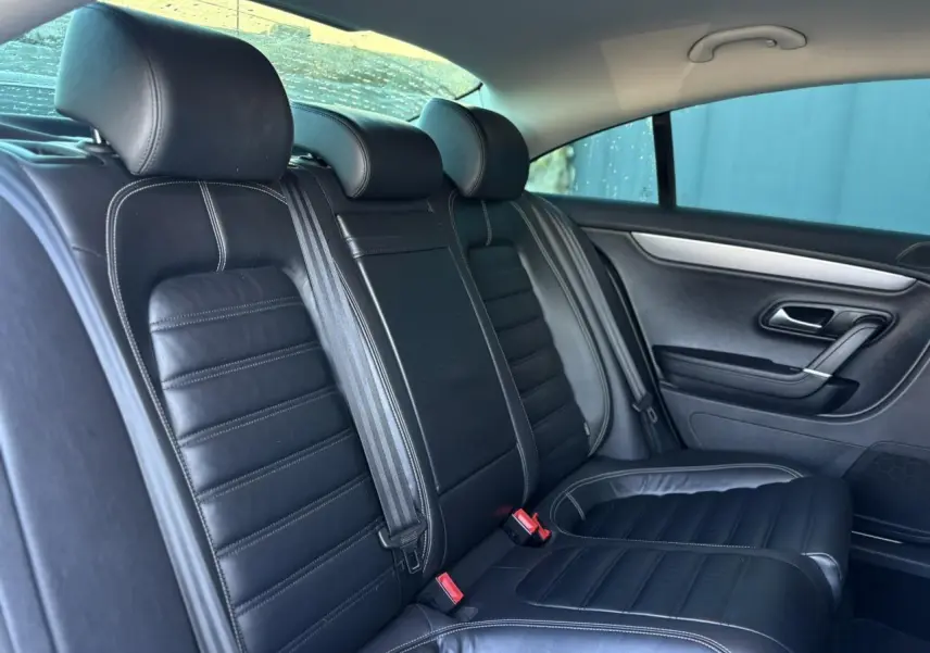 Vue intérieure des sièges arrière en cuir noir Nappa de la Volkswagen Passat CC 1.4 TSI 150 Carat, avec ceinture et accoudoir central.