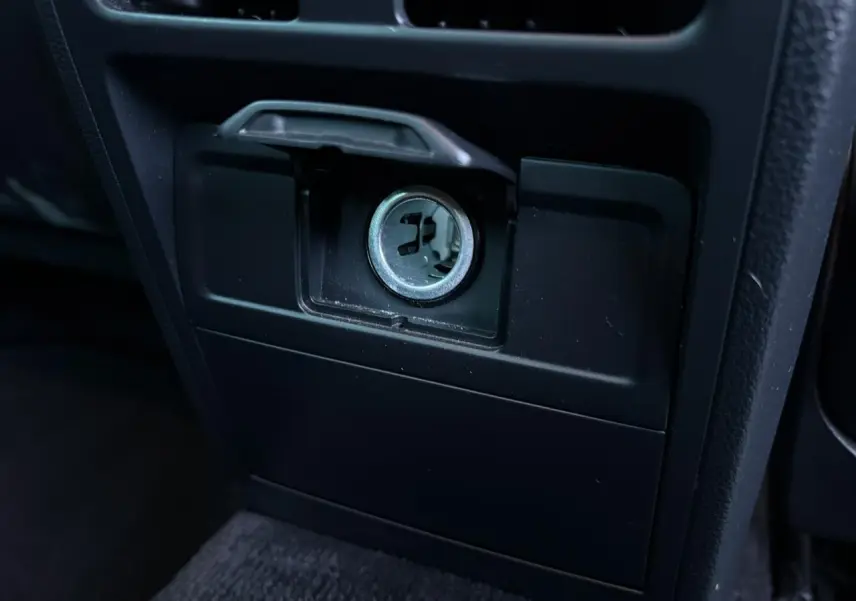 Gros plan sur la prise 12V du tableau de bord intérieur noir de la Volkswagen Passat CC 1.4 TSI Deep Black.