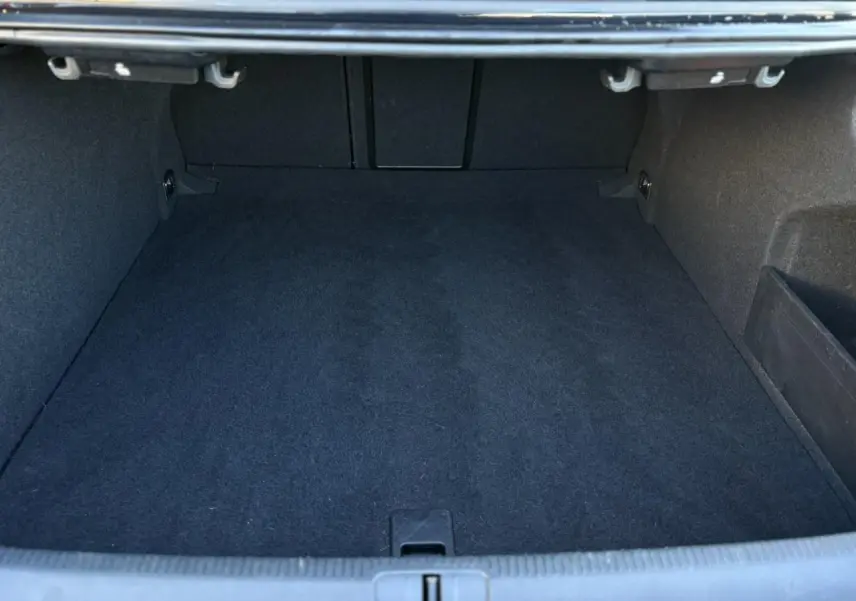 Coffre vide vu de face, intérieur noir profond, montrant l'espace de chargement du Volkswagen Passat CC 2015.