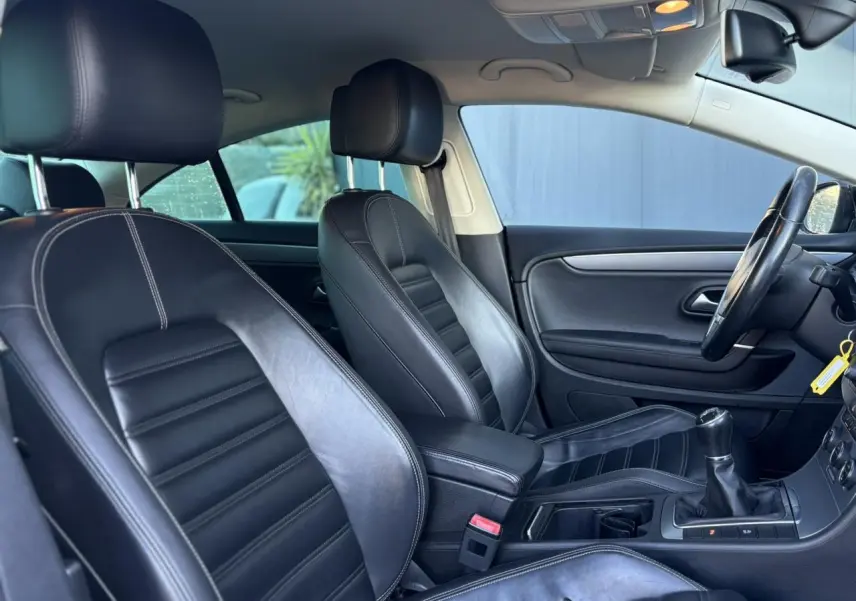 Vue intérieure côté conducteur de la Volkswagen Passat CC 1.4 TSI 2015 avec sellerie cuir Nappa noire et boîte manuelle.