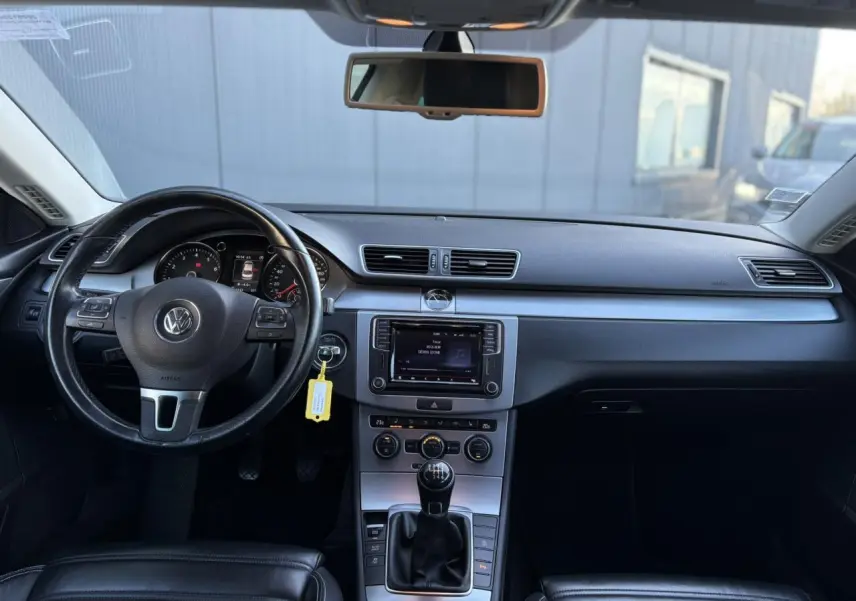 Vue intérieure avant de la Volkswagen Passat CC 1.4 TSI 2015 avec tableau de bord noir et volant cuir multifonction.